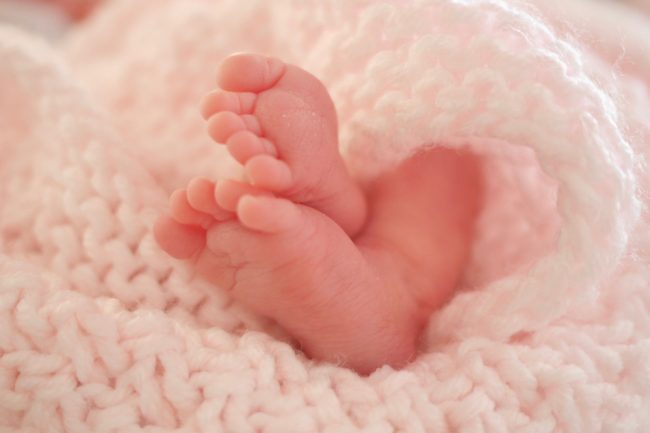 25,Weeker.,Premature,Baby,Feet,Wrapped,In,Blanket.,Lying,In