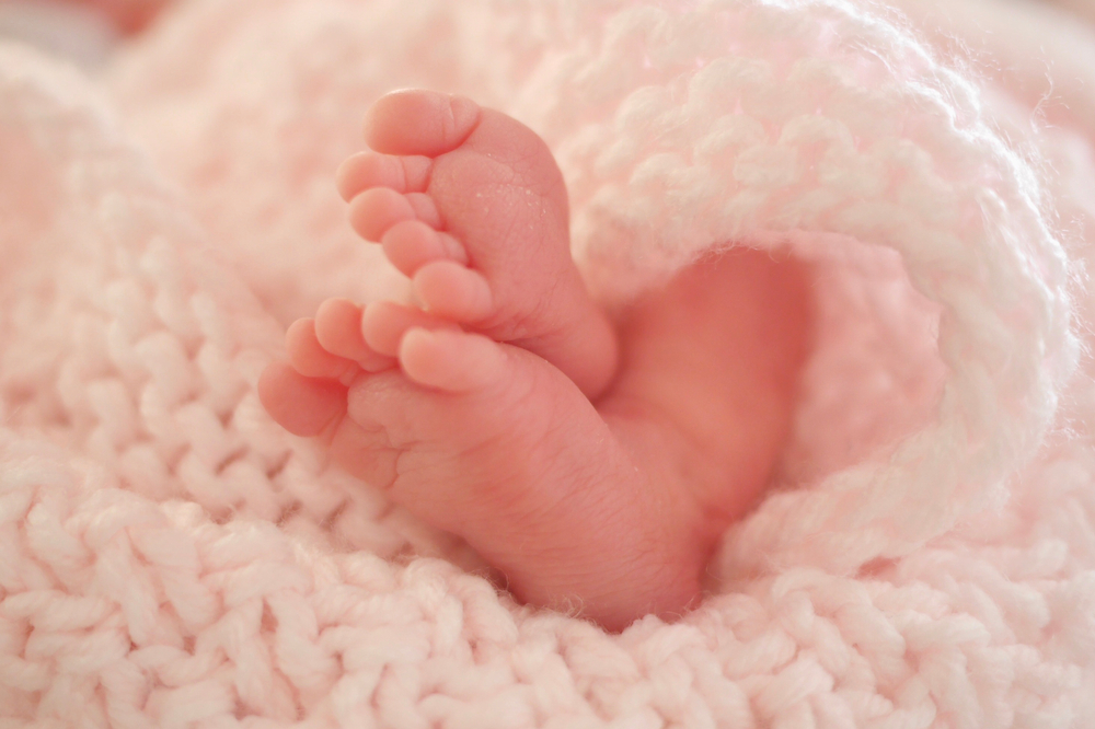 25,Weeker.,Premature,Baby,Feet,Wrapped,In,Blanket.,Lying,In